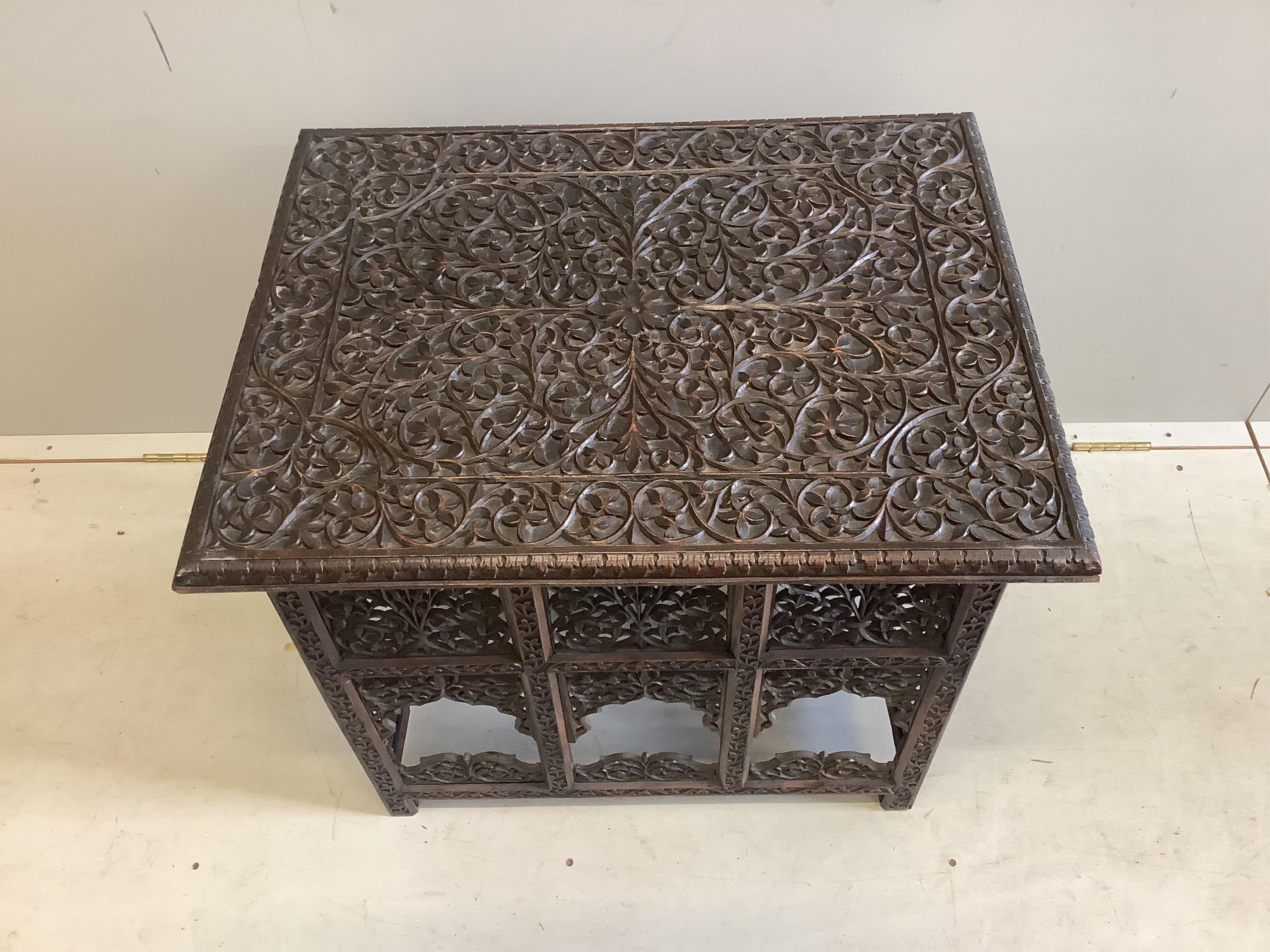 A late 19th century Burmese carved teak folding table, width 69cm, depth 55cm, height 163cm